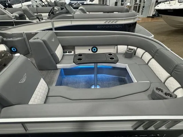 Slide: The Image of 2024 Bennington 25 LTSB pontoon boat interior with gray seating and blue LED lighting. - 19
