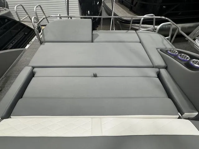Slide: The Image of 2024 Bennington 25 LTSB boat with gray cushioned seating and cup holders. - 24