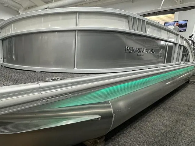 Slide: The Image of 2024 Bennington 25 LTSB pontoon boat with sleek silver design and green accent lighting. - 3