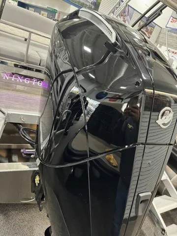 Slide: The Image of 2024 Bennington 25 LTSB boat with sleek black engine in showroom. - 34