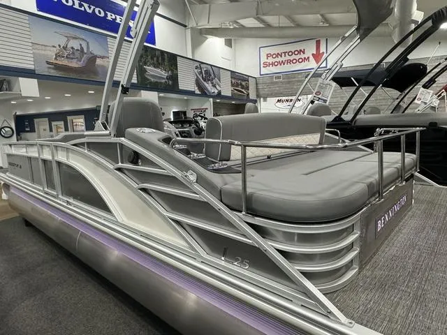 Slide: The Image of 2024 Bennington 25 LTSB pontoon boat in showroom, sleek design, luxury seating. - 6