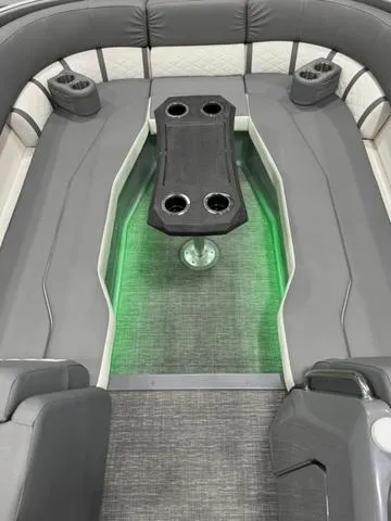 Slide: The Image of 2024 Bennington 25 LTSB boat interior with gray seating and green LED lighting. - 7