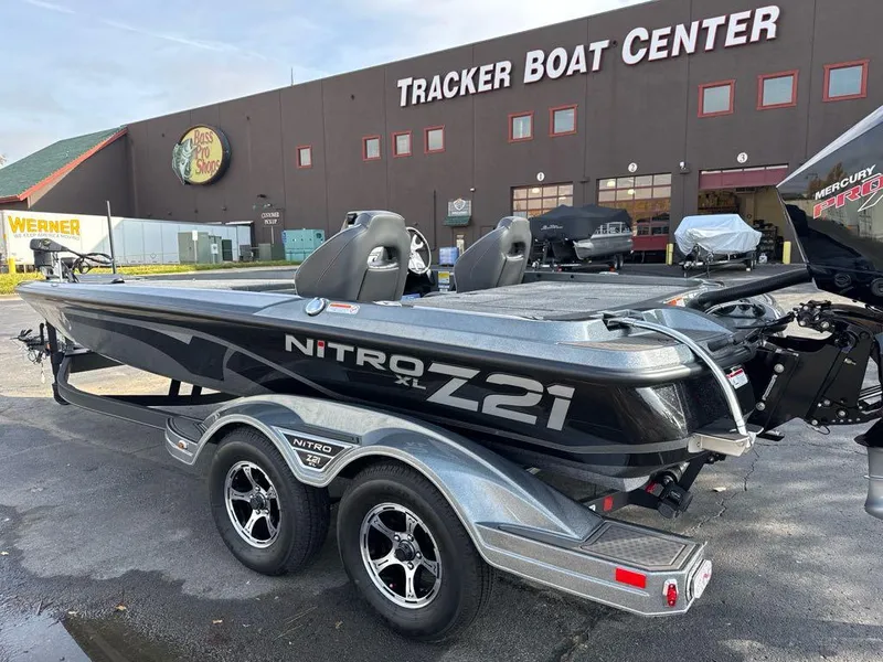 Slide: The Image of 2024 Nitro Z21 XL boat on trailer in front of building. - 2