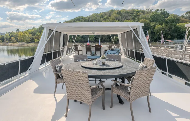 Slide: The Image of Luxury yacht deck with wicker dining set, surrounded by scenic lake and forest views. - 10