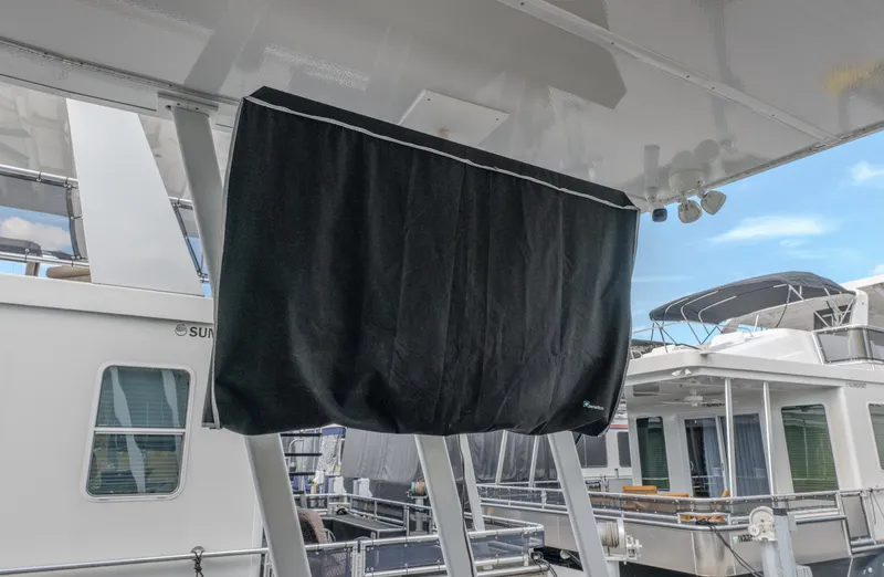 Slide: The Image of Covered equipment on a 2007 Fantasy 19 X 90 houseboat, docked with other boats. - 13