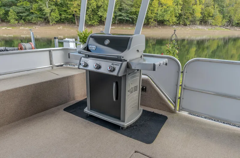 Slide: The Image of Outdoor grill on a 2007 Fantasy 19 X 90 houseboat deck by a lake. - 14