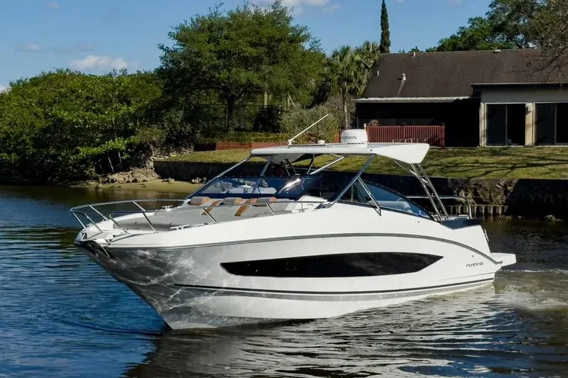 The Image of 2024 Beneteau Flyer 10 cruising on a serene river near a house. - 0