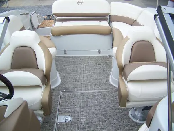 Slide: The Image of 2016 Crownline E4 boat interior with beige and white seating, gray carpet, and spacious layout. - 15