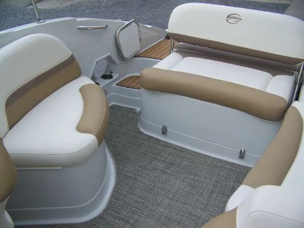 Slide: The Image of 2016 Crownline E4 boat interior with beige and white seating, featuring a carpeted floor. - 16