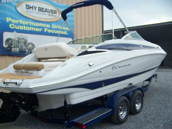 Slide: The Image of 2016 Crownline E4 boat on trailer at dealership, featuring sleek design and blue accents. - 7