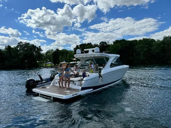 Slide: The Image of 2023 Regal LS36 boat on a lake with people enjoying the sunny day. - 2