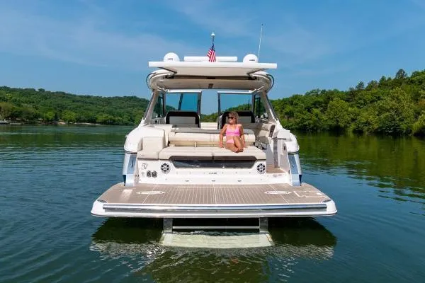 Slide: The Image of 2023 Regal LS36 boat on a lake with a person relaxing on deck. - 4