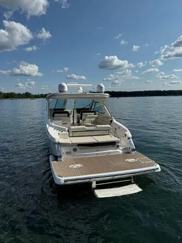 Slide: The Image of 2023 Regal LS36 boat on a calm lake under a partly cloudy sky. - 5