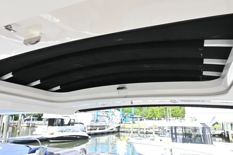 Slide: The Image of 2019 Sea Ray SLX 400 boat with open sunroof, clear sky, and scenic view. - 27