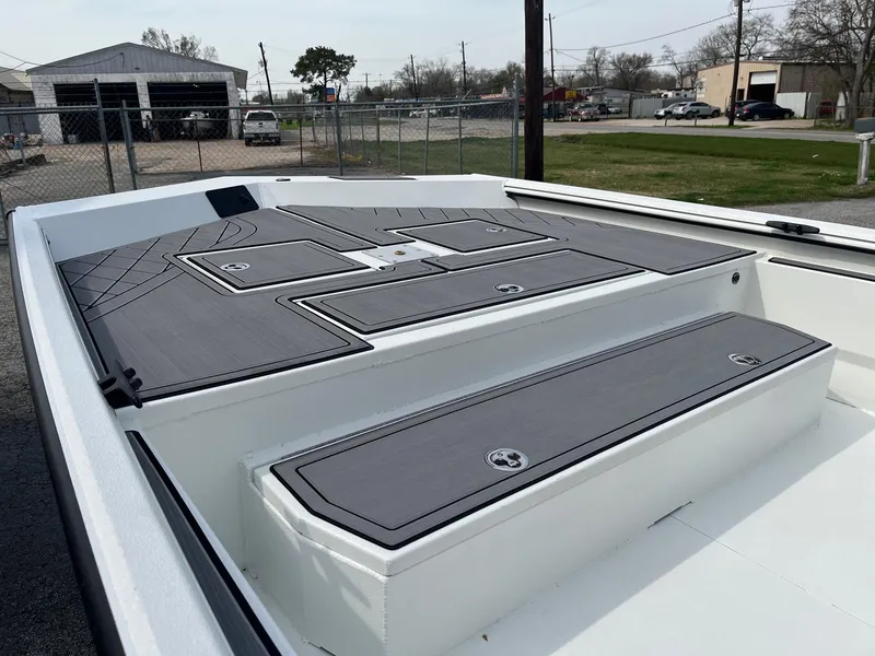Slide: The Image of 2024 Avid 20 Rogue boat deck with storage compartments in a marina. - 4