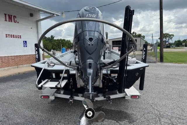 Slide: The Image of 2024 Avid 23 Fusion boat with powerful outboard motor, parked near storage facility. - 5