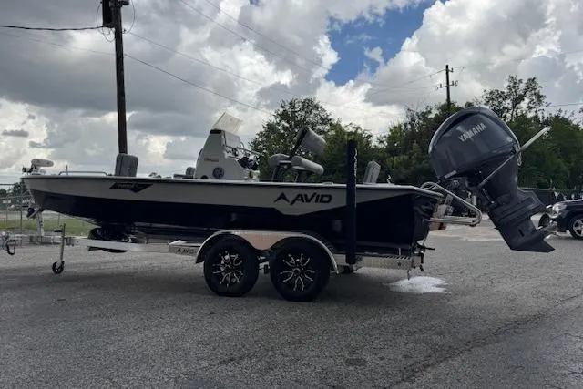 Slide: The Image of 2024 Avid 23 Fusion boat on trailer with Yamaha outboard motor, parked outdoors. - 6
