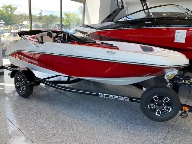 The Image of 2022 Scarab 165 jet boat in showroom, red and white color scheme. - 2