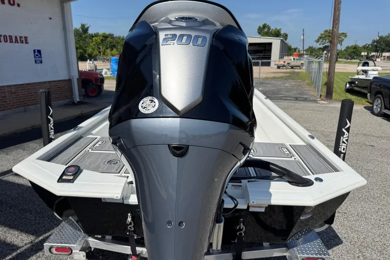 Slide: The Image of 2024 Avid 23 Mag boat with powerful 200 HP engine, parked outdoors. - 7