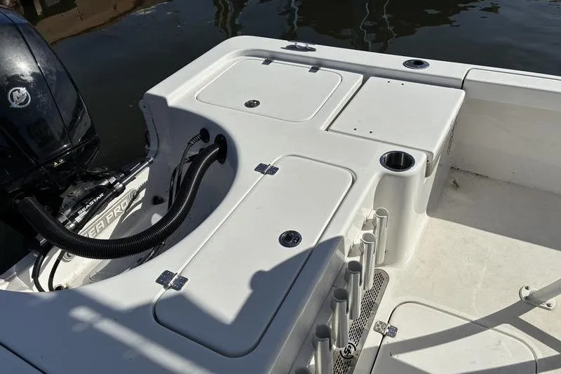 Slide: The Image of 2023 Sea Pro 208 Bay boat deck with storage compartments and motor. - 10