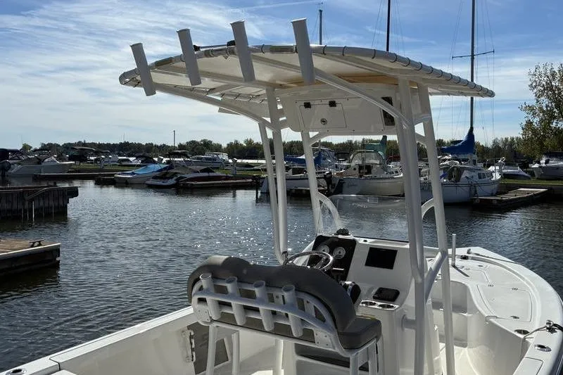 Slide: The Image of 2023 Sea Pro 208 Bay boat docked in a marina under a clear blue sky. - 13