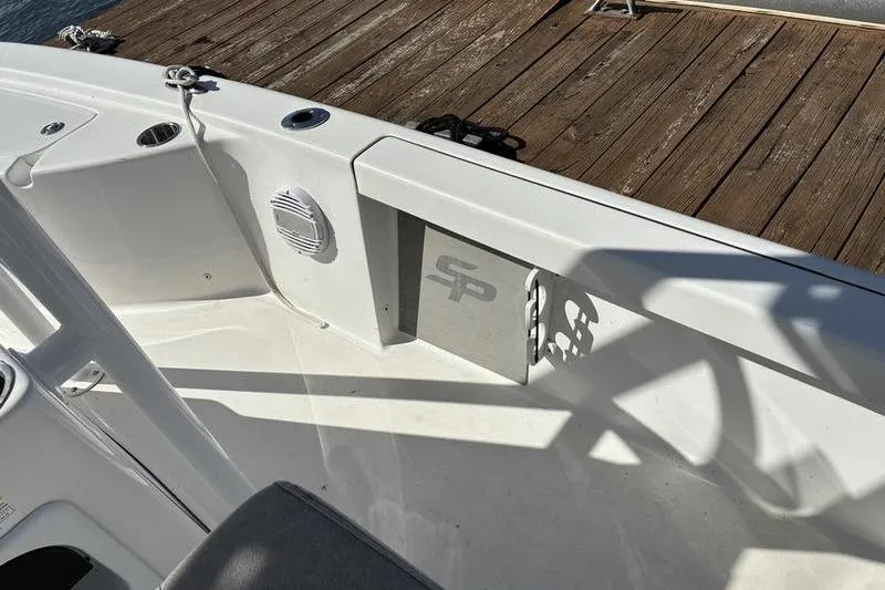 Slide: The Image of 2023 Sea Pro 208 Bay boat interior with dock view, featuring sleek white design. - 18