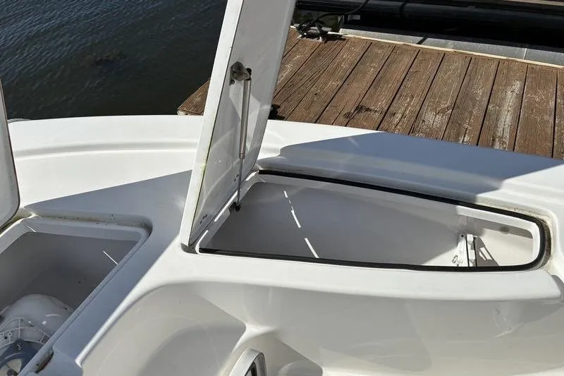 Slide: The Image of 2023 Sea Pro 208 Bay boat storage compartments open on a dock. - 20