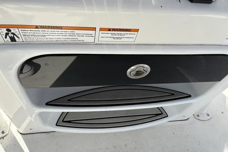 Slide: The Image of 2023 Sea Pro 208 Bay boat dashboard with warning labels and storage compartment. - 23