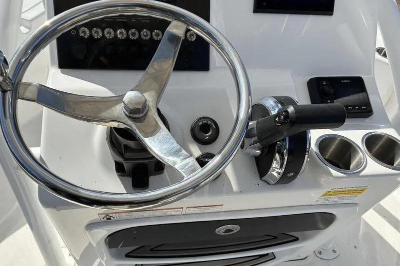 Slide: The Image of 2023 Sea Pro 208 Bay boat helm with steering wheel and controls. - 24
