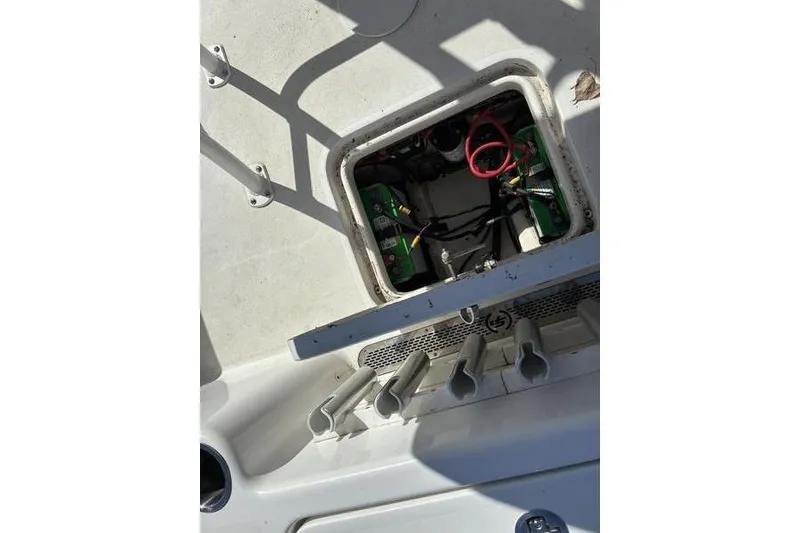 Slide: The Image of 2023 Sea Pro 208 Bay boat battery compartment with wiring and rod holders. - 27