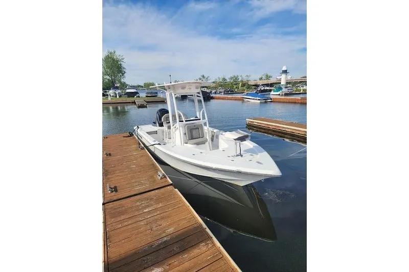 Slide: The Image of 2023 Sea Pro 208 Bay boat docked in a marina under a clear blue sky. - 29
