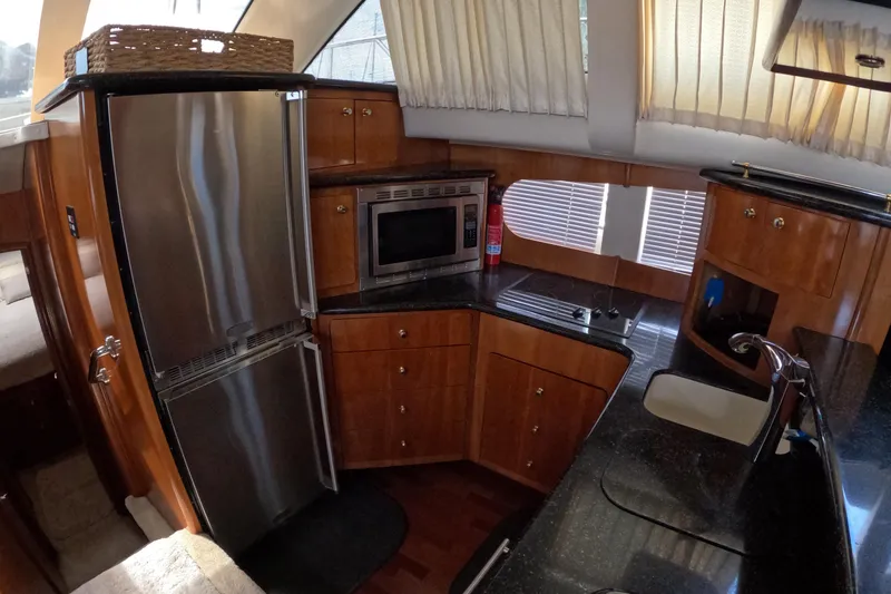 Slide: The Image of 2001 Carver 506 Motor Yacht kitchen with stainless steel appliances and wooden cabinetry. - 30