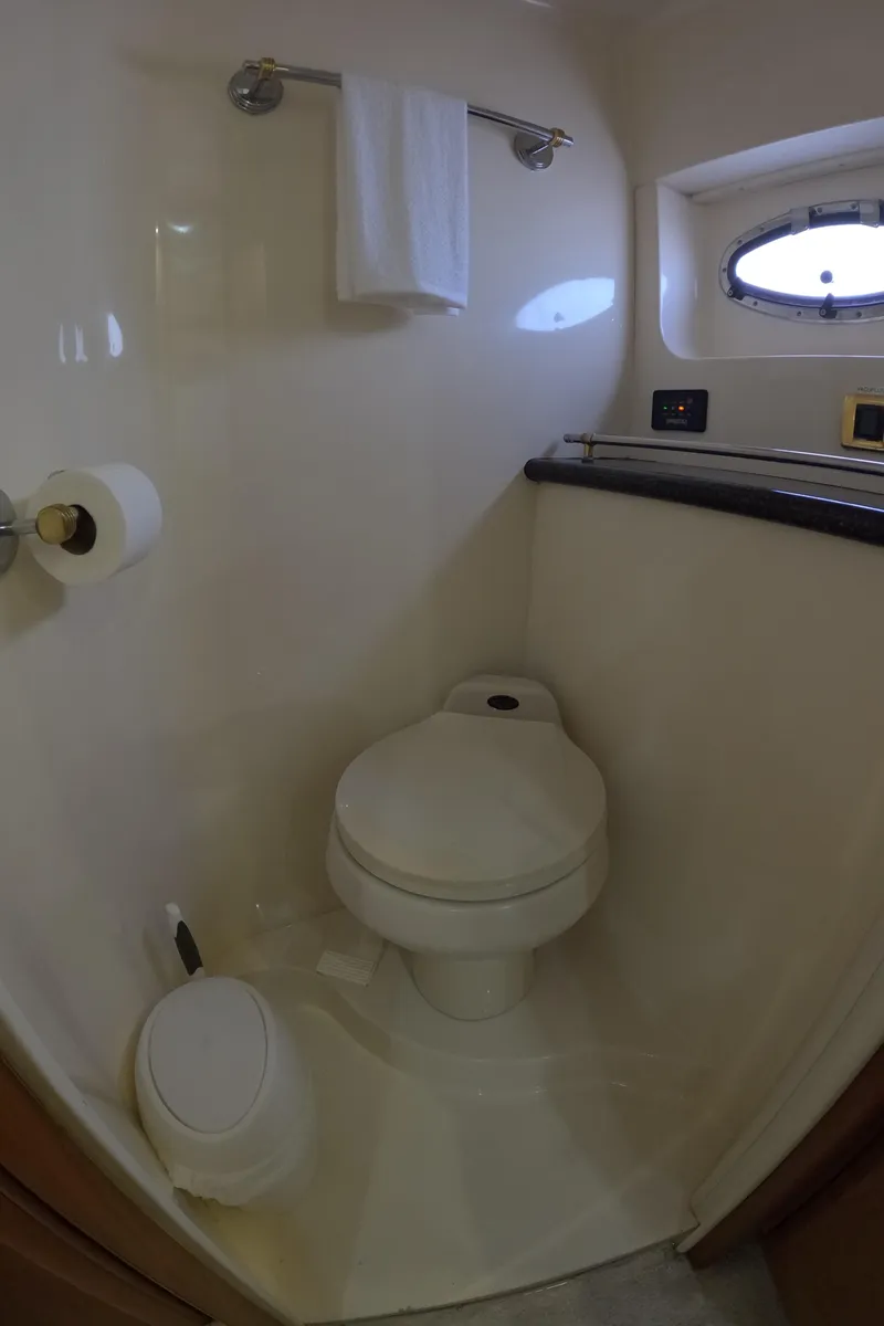 Slide: The Image of 2001 Carver 506 Motor Yacht bathroom with toilet, towel rack, and porthole window. - 47