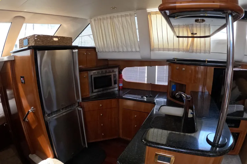 Slide: The Image of 2001 Carver 506 Motor Yacht kitchen with stainless steel appliances and wooden cabinetry. - 31