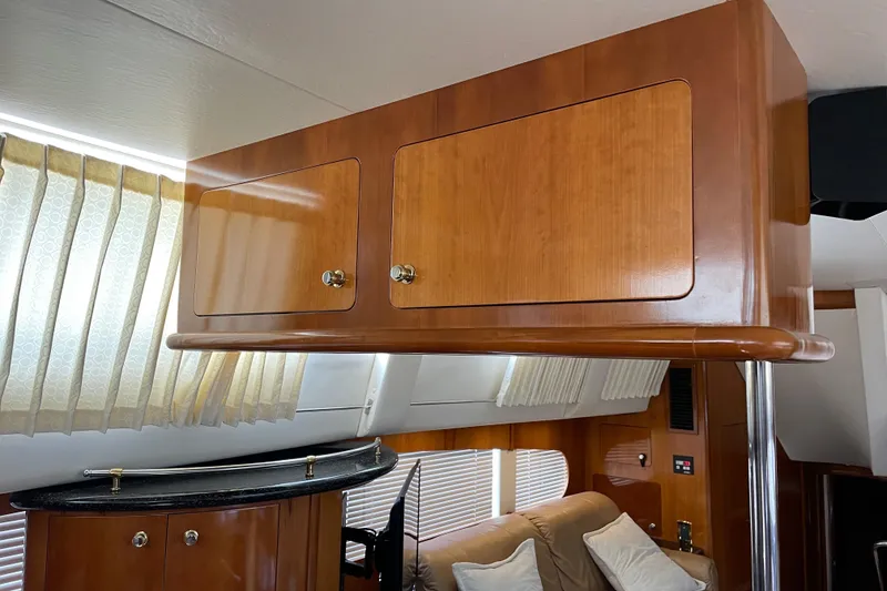 Slide: The Image of Interior of 2001 Carver 506 Motor Yacht with wooden cabinets and beige curtains. - 36