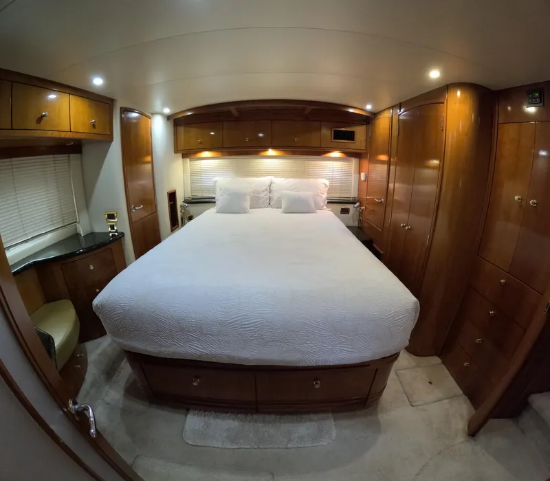 Slide: The Image of Luxurious bedroom in a 2001 Carver 506 Motor Yacht with wood cabinetry and a large bed. - 38