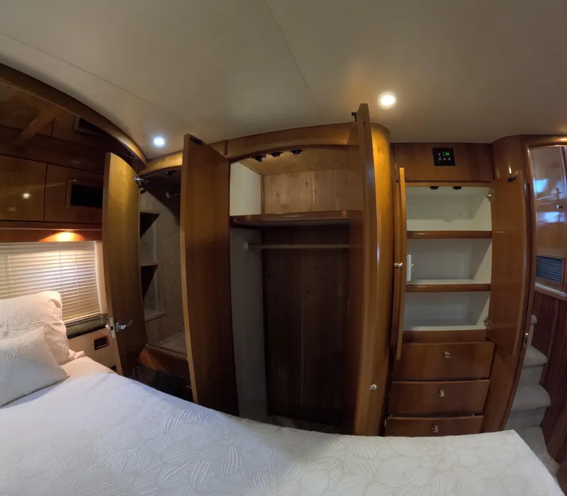 Slide: The Image of Interior of 2001 Carver 506 Motor Yacht bedroom with open closets and wooden cabinetry. - 40