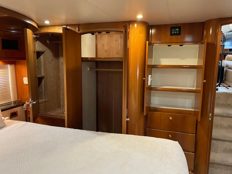 Slide: The Image of Interior of 2001 Carver 506 Motor Yacht with wooden cabinetry and open closet. - 43