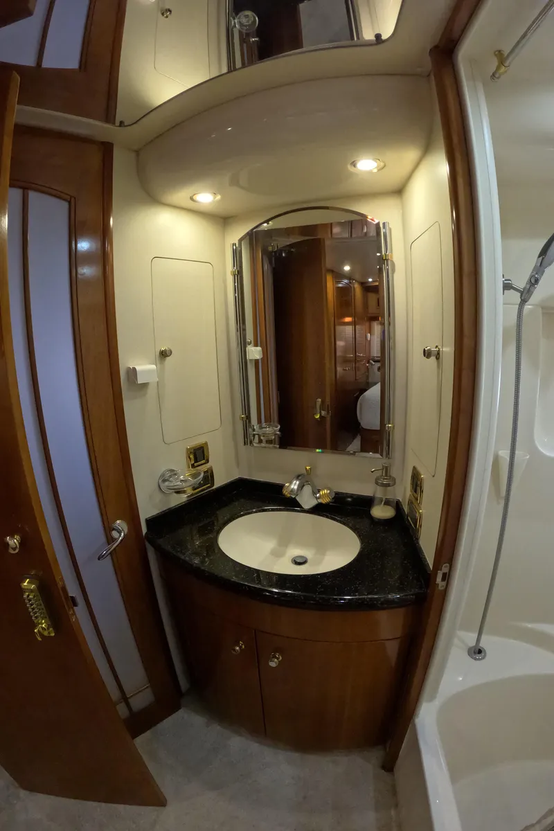 Slide: The Image of Bathroom vanity in 2001 Carver 506 Motor Yacht with black countertop and mirror. - 48