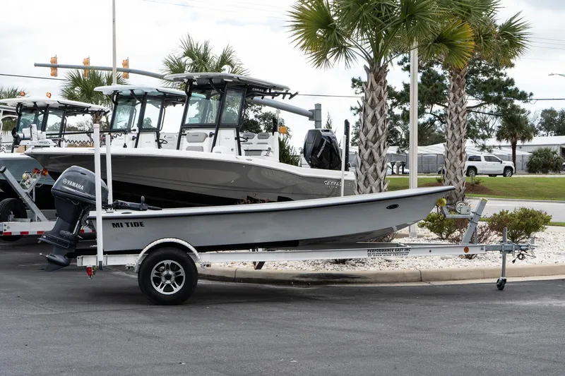 Slide: The Image of 2024 Mi Tide V1503 boat on trailer, parked near palm trees. - 2