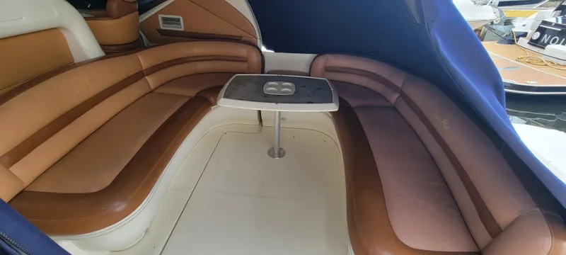 Slide: The Image of 2004 Sea Ray 455 Sundancer interior seating area with a central table. - 12