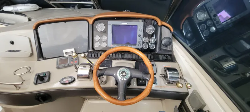 Slide: The Image of 2004 Sea Ray 455 Sundancer helm with navigation instruments and wooden steering wheel. - 16