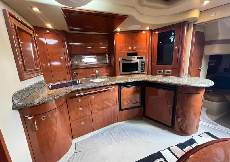 Slide: The Image of Luxurious 2004 Sea Ray 455 Sundancer yacht kitchen with modern appliances and wooden cabinetry. - 24