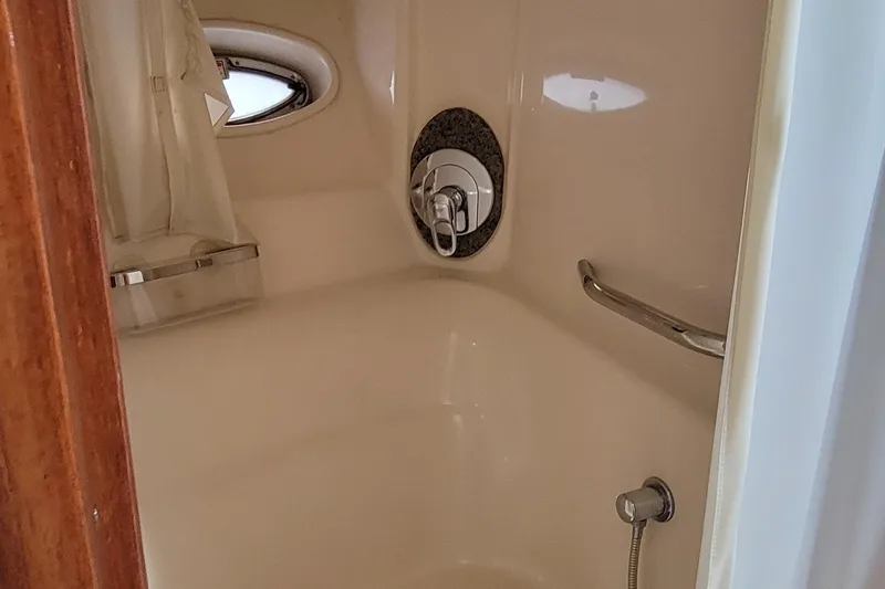 Slide: The Image of 2004 Sea Ray 455 Sundancer yacht bathroom with shower and porthole window. - 28