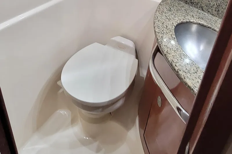 Slide: The Image of 2004 Sea Ray 455 Sundancer bathroom with toilet and granite sink. - 29