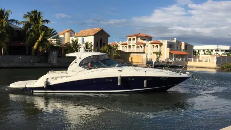 Slide: The Image of 2004 Sea Ray 455 Sundancer yacht cruising near luxury waterfront homes. - 3