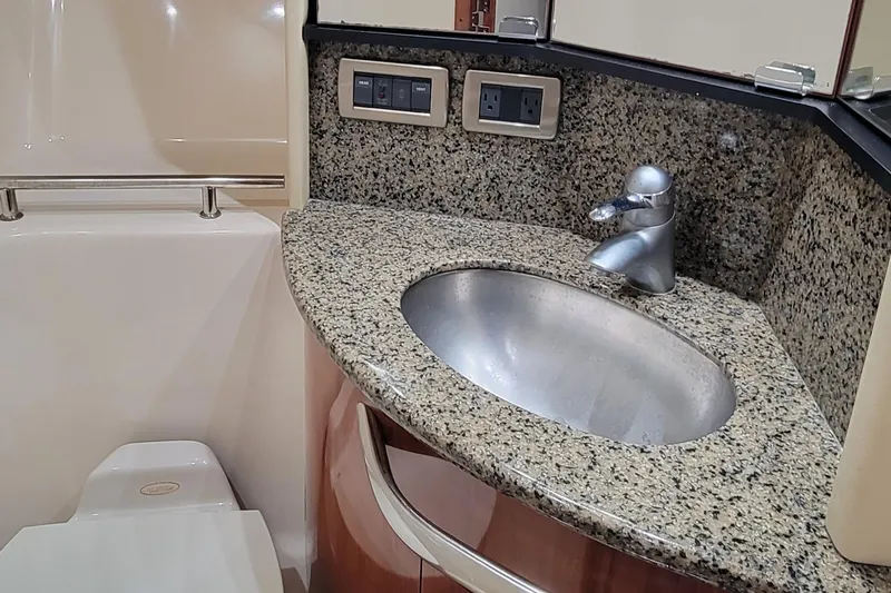 Slide: The Image of 2004 Sea Ray 455 Sundancer bathroom with granite countertop and stainless steel sink. - 30
