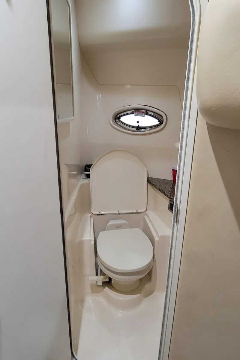 Slide: The Image of 2004 Sea Ray 455 Sundancer yacht bathroom with toilet and porthole window. - 32