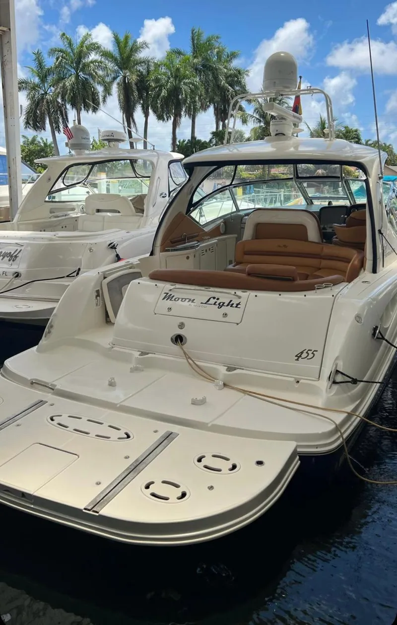 Slide: The Image of 2004 Sea Ray 455 Sundancer yacht docked with palm trees in the background. - 4
