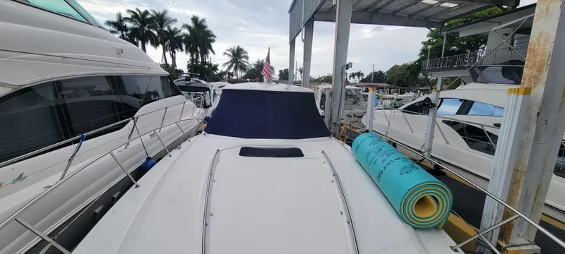 Slide: The Image of 2004 Sea Ray 455 Sundancer yacht docked at marina with rolled-up mat on deck. - 6